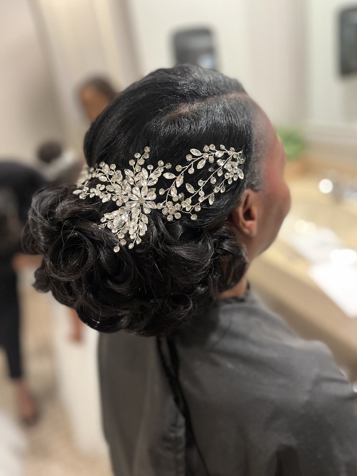 A formal updo finished with a crystal hairpiece
